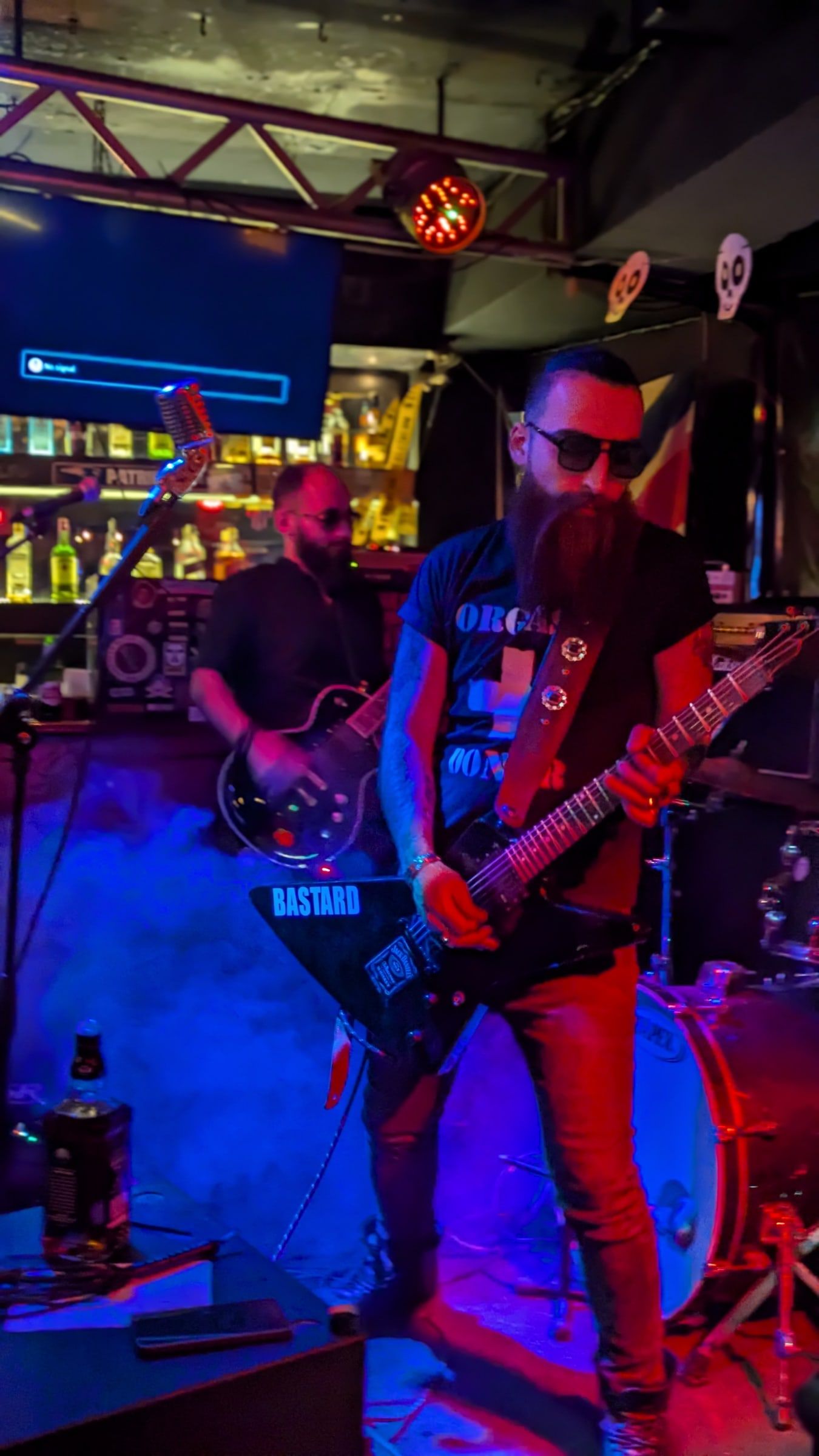 Two guitarists in front of the bar